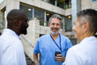 © Davor - Smiling healthcare workers talking outside hospital
