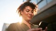 © Z A C - Smiling Woman Texting Outdoors on Sunny Day