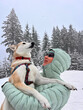 © Oleksandr Stalovierov/Stocksy - Happy woman holding her dog during a winter adventure in the Austrian
