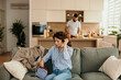 © La Famiglia - Woman preparing for her day while man cooks in the kitchen