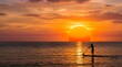 © Sophia - Silhouette of a man paddle boarding on ocean water during a golden sunset