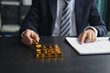 © Supitnan - Gold investment Concept. Businessman working on financial planning and gold investment analysis with bullion on desk.