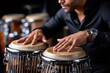 © YouraPechkin - Musician plays conga drums with focus in a lively performance setting