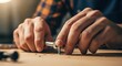 © Khaisan - Person's hands using a screwdriver on a wooden surface indoors
