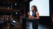 © True Stock - Confident South Asian woman speaking at a podium on stage