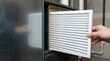 © Imaginex Rahad27 - Hand installing a clean white air filter into an HVAC ventilation unit