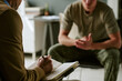 © AnnaStills - Young adult man in military hospital receiving counseling session, discussing recovery and mental health support with clinician. Useful for veteran care, trauma therapy, rehabilitation marketing