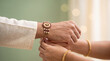 © Ankit - A woman tying a decorative rakhi bracelet onto her brothers wrist during the traditional festival