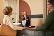 © Rido - Happy receptionist during guest registration at the hotel