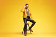 © Ljupco Smokovski - Stylish man in a yellow jacket sitting on a stool