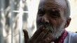 © ExpressVectors - Portrait of senior despair ukrainian man smoking cigarette at summer garden. Elderly sad bearded male in embroidered shirt looking into camera outdoor. Mature human in vyshyvanka with upset emotions