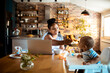 © Marko Geber - Mother working from home feeding baby in kitchen