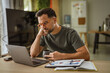 © Miljan Živković - Man concentrating on laptop working from home office