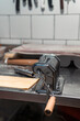 © andreas - Pasta Maker in Kitchen: A classic pasta machine is set up on a metal counter in a clean kitchen, ready to transform dough into fresh, homemade pasta.