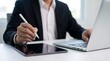 © Studio KN - business professional using digital tablet and laptop for real time business analysis and collaborative office workflow