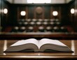 © Hasyim - An open book lies on a polished wooden surface in a court of law