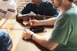 © Rawpixel.com - Diverse men in a meeting around a table, discussing with a tablet and notepad