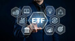 © MdSuhel - Businessman touching ETF exchange traded fund icon on virtual screen stock market