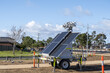 © Doublelee - A mobile solar-powered light tower stands on a trailer at a road construction site on roadside in Melbourne Australia. Temporary renewable-energy infrastructure supporting road works