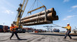 © Maximilian - Industrial workers guiding heavy steel pipes with a crane at a busy port.