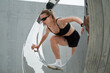 © Dmitry Homich/Stocksy - Sporty woman standing inside modern sculptural composition