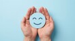 © Funster - Positive thinking and emotional wellness illustrated by hands holding a blue smiley face cutout.