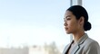 © Undersea - Young Asian woman in business attire gazing thoughtfully out window, professional contemplation and career aspirations concept for corporate and leadership themes.