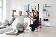© Pixel-Shot - Senior man with dumbbells and therapist training on fitball in rehabilitation center