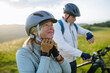© Halfpoint - Older bikers taking break during bike ride and checking their performance on smartwatch.