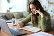 © PheelingsMedia - Stressed teleworker talking on phone checking agenda
