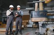 © Serhii - Furniture factory workers using laptop next to cnc machine