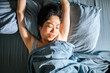 © Davor - Woman waking and stretching in bed at home