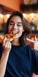 © Andrii Zastrozhnov - Happy woman enjoying a cheesy pizza slice and pointing for energetic casual dining banner and social media content
