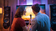© Konstantin Yuganov - Couple Enjoying Karaoke Night at Home with Microphone