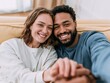 © Breezze - Happy young couple taking a selfie while relaxng on a sofa, providing an affectionate and airy lifestyle feel for relationship and wellness content