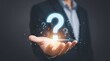 © Sulastri - Businessman holding glowing question mark symbol concept for problem solving and FAQ