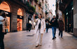 © BullRun - Smiling woman taking selfie on crowded pedestrian street, female traveler using smartphone for vlogging, authentic representation of digital nomad life and social media engagement in the city.