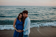 © Westend61 - Expecting couple embracing on the beach at dusk