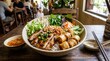 © Iqra - Delicious bowl of Vietnamese noodle salad with grilled pork and fresh herbs served in a cozy restaurant