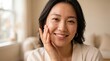 © Ctra - Portrait of a smiling young woman with clear glowing skin touching her face in a bright and cozy minimalist home setting