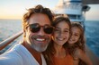 © Margarita - man and young girl taking a warm sunset selfie on a cruise ship deck, embracing and smiling with ocean and ship structure in the background