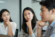 © Pixel-Shot - Confused asian businesswoman with furrowed brow listening intently during a corporate meeting or presentation, She appears thoughtful and pensive