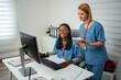 © Jelena - Diverse medical workers collaborating on computer and digital tablet