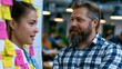 © Maksym Tereshchenko - Startup founder coaching a junior publicist at a standing whiteboard, mapping out media outreach strategy with sticky notes and journalist contact lists, a busy coworking space buzzing behind them,