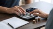 © Ayesha - Hands calculating car loan cost with coins and miniature vehicle on desk for financial planning