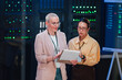 © Zamrznuti tonovi - It professionals discussing data center operations, analyzing information on a clipboard in server room