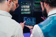 © Zamrznuti tonovi - It professionals collaborating, observing a network diagram and data on a tablet display in a data center