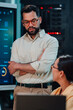 © Zamrznuti tonovi - It professional explaining data analysis and server performance to a colleague in a modern data center