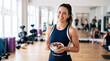 © INT888 - Smiling woman fitness gear bowl yogurt gym healthy breakfast after workout with fruit and granola, active adult enjoying nutrition in bright exercise studio