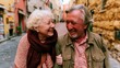 © Breezze - Senior couple walking arm in arm on a warm cobblestone street, sharing a candid laugh for retirement lifestyle and active senior travel content